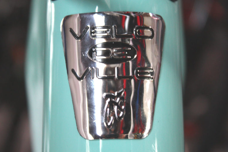 Das Logo der Fahrradmarke Velo de Ville wird als Detailfotografie auf einem Fahrradrahmen dargestellt.