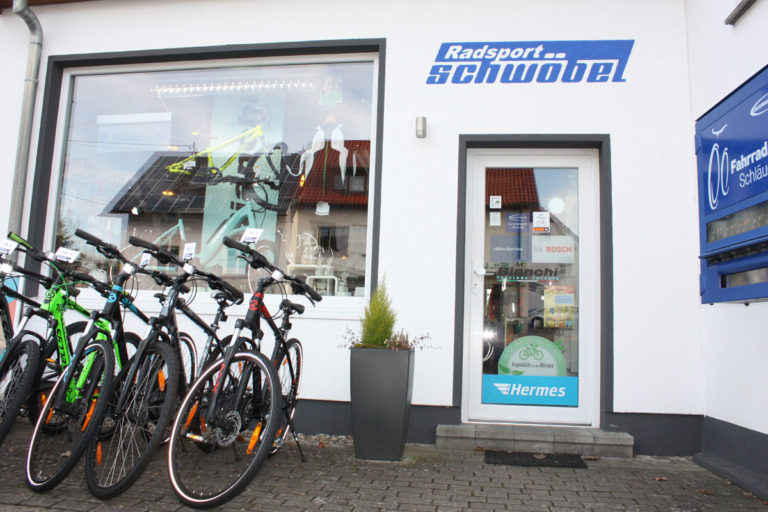 Das Schaufenster von Radsport Schwöbel wird dargestellt. Davor stehen einige Fahrräder.