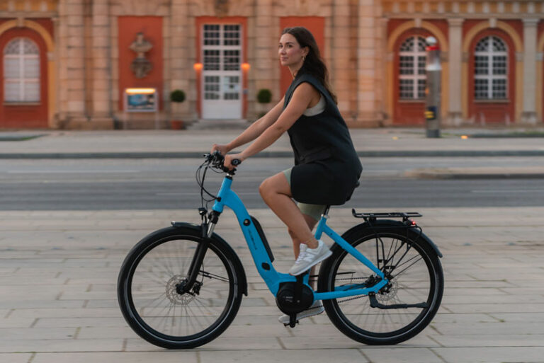 Eine Frau fährt auf einem türkisblauen Fahrrad