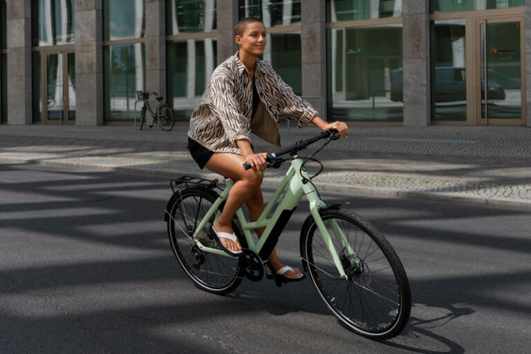 Eine Frau fährt auf einem hellgünen Fahrrad